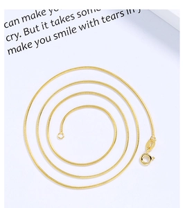 Macro detail of gold-plated S925 sterling silver snake chain with lobster clasp and stamp