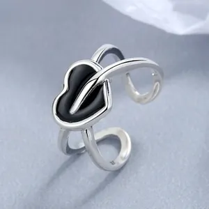 Macro shot of 925 sterling silver heart ring with black enamel and split band design