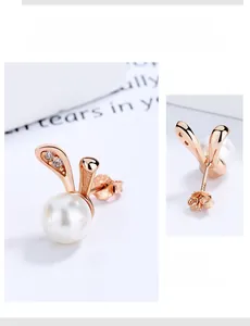 Detail of rose gold rabbit pearl earrings showing round shell pearls and zircon accents