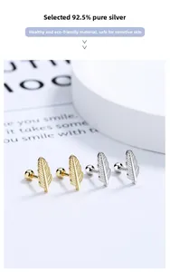 Detailed macro view of 925 sterling silver feather stud earrings in gold and silver