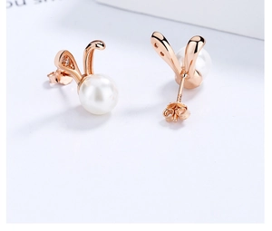 Macro view of rose gold bunny pearl earrings with sparkling stones and butterfly clasp