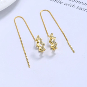 Detail of gold box chain earrings with zigzag pendants and white micro-set zircons