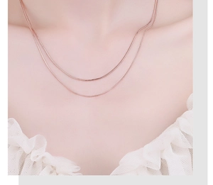Detail of rose gold double-layered snake chain choker necklace showing elegant metallic luster