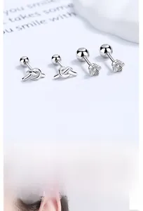 Macro detail of 925 sterling silver flower and knot stud earrings with screw backs