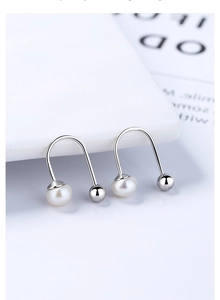 Detailed view of U-shaped S925 silver earrings with freshwater pearl and metallic ball