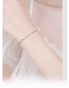 Detail of silver Cupid star moon bracelet with pavé moon charm worn on a female wrist