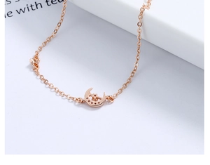 Detailed close-up of a rose gold moon and star bracelet with sparkling zircon crystals