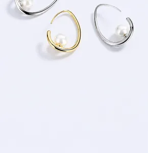 Vue détaillée des boucles d'oreilles perles argentées et dorées au design épuré
