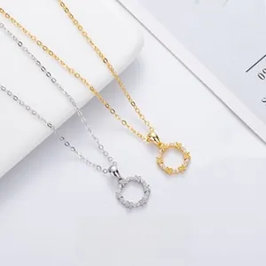 Detail of silver and gold four-leaf clover round necklaces with zircon inlay