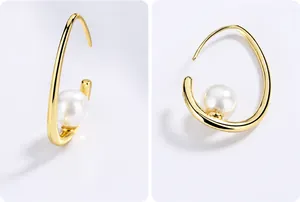 Détail de boucles d'oreilles croissants dorés avec perles et texture polie à la main