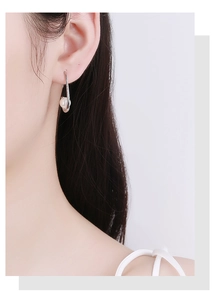 Détail de boucles d'oreilles lune et perle élégantes sur modèle en argent 925