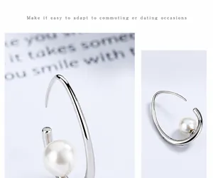 Vue détaillée de boucles d'oreilles lune argentées avec perles élégantes et design épuré en forme de C