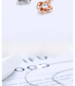 Macro detail of a rose gold openwork four-leaf clover pendant with a sparkling zircon