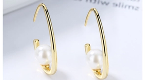 Macro de boucles d'oreilles croissants dorés avec des perles blanches élégantes