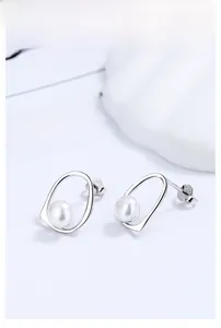Detail of irregular S925 silver earring with a natural white pearl and hallmark engraving