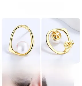 Detailed view of handmade geometric gold earrings with natural freshwater pearls