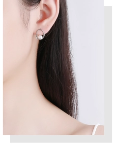 Close-up of a 925 sterling silver geometric earring with a freshwater pearl on model