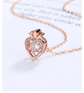 Detailopname van een roségouden hart hanger met een schitterende bewegende steen