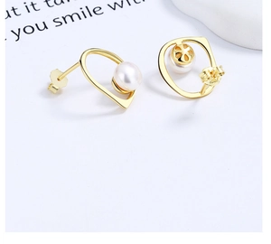 Detail view of gold geometric hoop earrings with irregular pearls and hollow flower backs