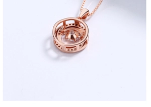Detailed close-up of a rose gold circular pendant with a dancing zircon on a box chain