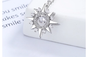 Macro shot of silver sterling sunburst necklace pendant with moving center stone detail