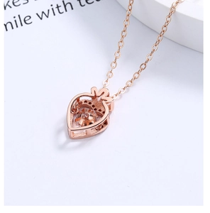 Detail van de roségouden aardbeienhanger met fonkelende steen en fijne zilveren ketting