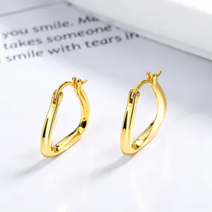 Boucles d'oreilles triangles torsadées minimalistes en argent doré vues sous un angle latéral