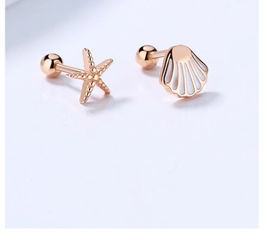Detail of rose gold starfish and white scallop screw-back stud earrings on blue background