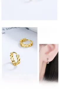 Detailed close-up of gold and silver hollow heart earrings showing elegant design and fit