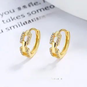 Detail view of gold interlocking hoop earrings with sparkling white cubic zirconia stones