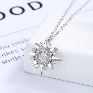 Sparkling silver starburst necklace with dancing cubic zirconia on geometric white pedestal