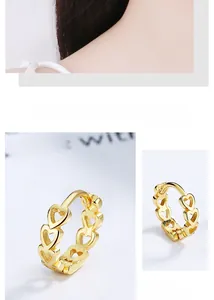 Macro detail of gold-plated hollow heart earrings showing polished finish and craftsmanship