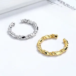 Close-up of gold and silver twisted rope rings with a polished mirror finish on white