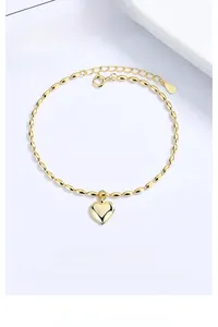 Detail of S925 sterling silver gold heart pendant on olive bead chain bracelet