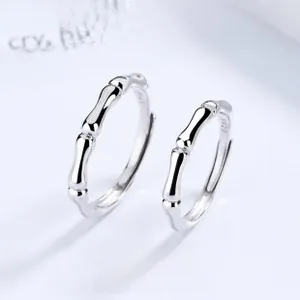 Dettaglio degli anelli di coppia in argento 925 con design a bambù e marchio S925