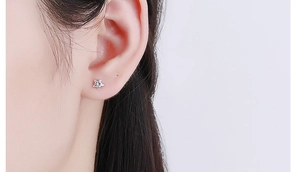 Macro shot of a minimalist 925 silver star stud earring with a sparkling zircon stone