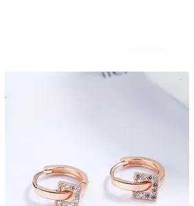 Détail macro de boucles d'oreilles or rose serties de zircones et poinçon S925