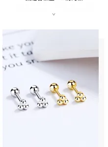 Macro shot of S925 sterling silver ball stud earrings in gold and silver finishes