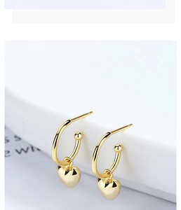 Détail de boucles d'oreilles cœur dorées montrant le poinçon en argent massif S925