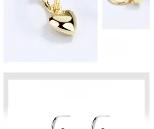 Gros plan de boucles d'oreilles cœur dorées, design minimaliste et finition polie