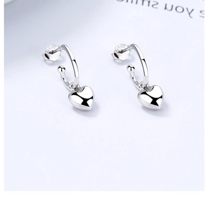 Détail de boucles d'oreilles cœur en argent S925 avec finition polie et poinçons