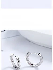 Macro shot of silver hoop earrings with traditional Chinese wave pattern relief details
