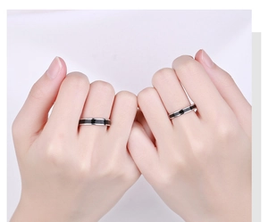 Dettaglio di anelli per coppia minimalisti con strisce in smalto nero su argento