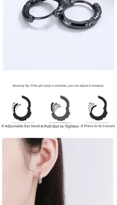 Macro view of black S925 sterling silver hoop earrings with tribal totem engraving
