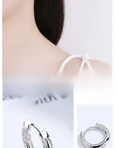 Macro view of sterling silver hoop earrings with intricate vintage cloud pattern engraving