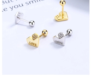 Detailed macro view of heart-shaped LOVE earrings with sparkling zircon and screw back