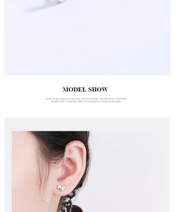 Model wearing a small 925 sterling silver heart stud earring with LOVE engraving and crystal