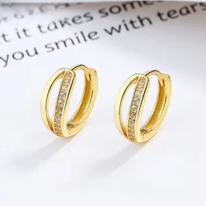 Macro shot of gold hollow double-layered hoop earrings with shimmering pave crystals