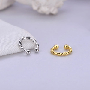 Macro shot of silver and gold C-shaped twisted chain ear cuffs with small bead ends