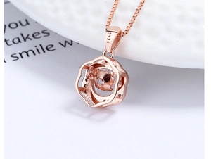 Vue macro du pendentif fleur évidée en argent S925 or rose avec pierre battante